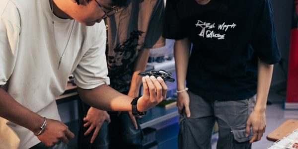 Two people looking at something in a person's hand.